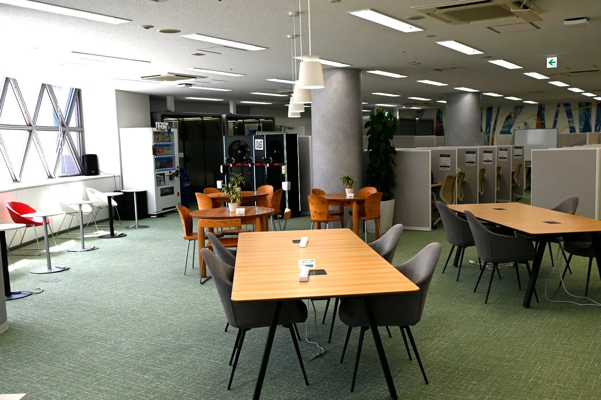AI VILLAGE 渋谷の室内。机と椅子が並ぶコワーキングスペース